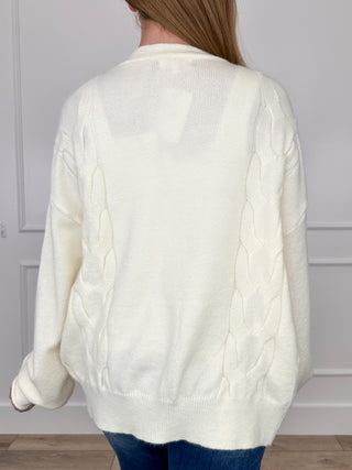 Cream knit long-sleeve cardigan with cable-knit texture on the back