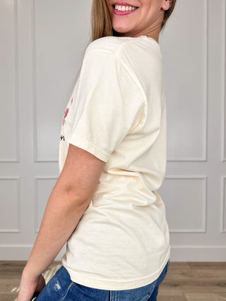 Cream cotton short-sleeve graphic tee, side view with partial colorful characters