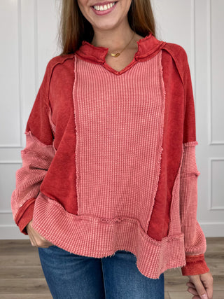Brick red hooded long-sleeve cotton top with kangaroo pocket and waffle-knit texture