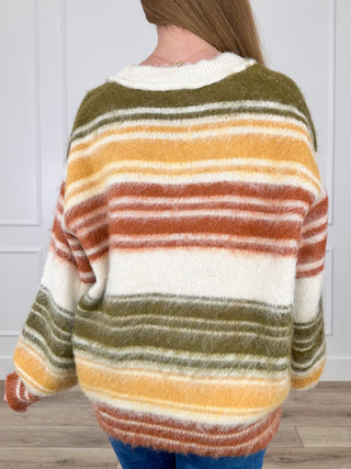 Back view of cream striped knit long-sleeve sweater with olive and orange bands