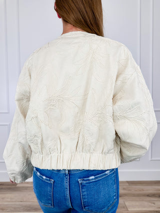 Cream cotton long-sleeve jacket, back view with embroidered design and elastic hem