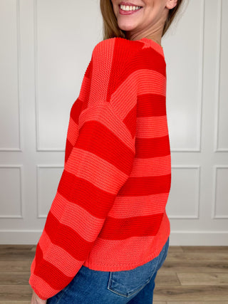 Red knit long-sleeve sweater top with horizontal stripes, crew neckline, side view