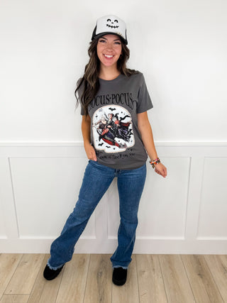 Women's casual outfit with gray graphic T-shirt, blue jeans, black shoes, light cap