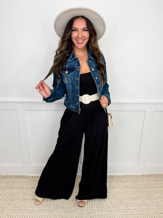 Denim jacket and black wide-leg jumpsuit with round belt buckle