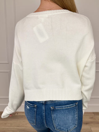 White cropped knit sweater with candy cane stripe print, long sleeves, back view