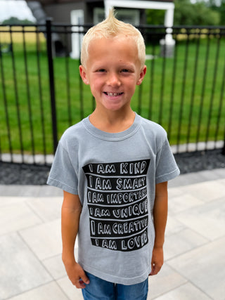 Kids grey short-sleeve graphic tee with black quote stack: I am kind, smart, loved.