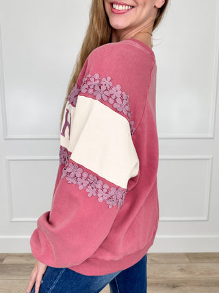 Pink crewneck sweatshirt with 'FAITH' graphic and floral lace trim on raglan sleeves
