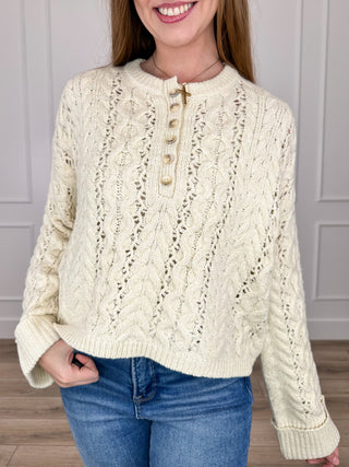 Cream cable-knit cropped sweater top with long sleeves and button placket