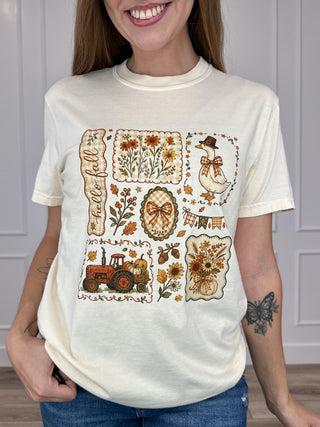 Cream short-sleeve cotton graphic tee with fall patches and “Hello” text