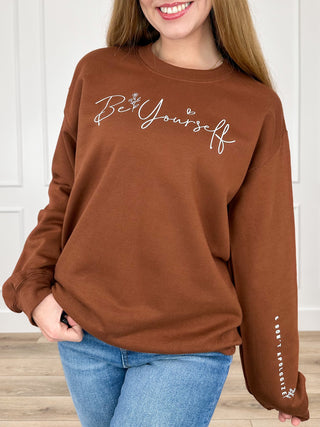 Brown long-sleeve crewneck sweatshirt with 'Be Yourself' graphic