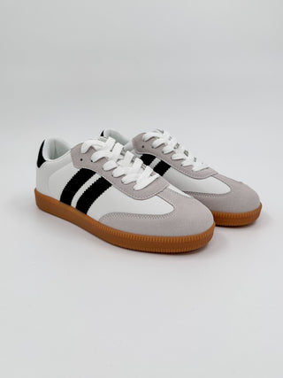 White faux leather sneakers with black side stripe, gray panels, lace-up, gum sole