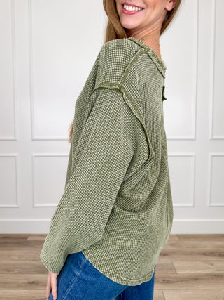 Green cotton-blend long-sleeve hooded top, side view with loose fit
