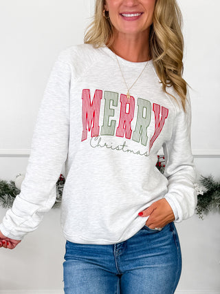 White long sleeve crewneck sweatshirt with large red “MERRY CHRISTMAS” graphic