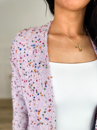 Speckled knit cardigan sleeve and shoulder detail in purple tones