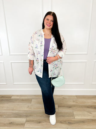 Floral lightweight jacket over dark blue jeans with white sneakers, mint crossbody bag