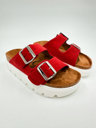 Faux suede slide sandals with two red buckle straps and white platform sole