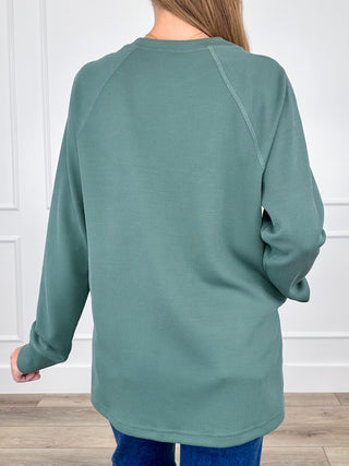 Forest green ribbed long-sleeve raglan top, back view with rounded crew neck