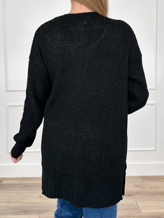 Black knit long-sleeve cardigan viewed from back, ribbed hem and cuffs