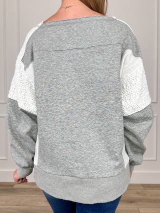 Gray long sleeve top with contrast lace-texture sleeve panels, relaxed back view