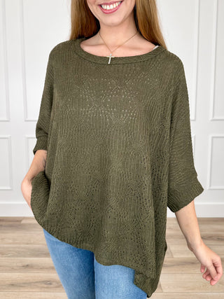 Olive green knit short-sleeve poncho top with draped hem and round neckline