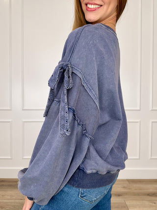 Blue cotton-blend long sleeve top, side view, tie sleeves with textured trim