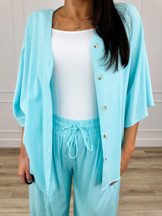 Blue button-front top with gold snaps over white camisole and drawstring pants