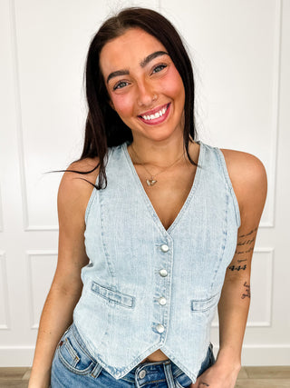 Light wash denim vest with sleeveless V-neck and button front, shaped hem