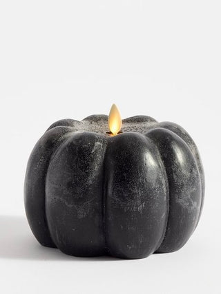 Black pumpkin LED candle with small glowing flame
