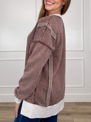 Women's brown long-sleeve V-neck pullover top with contrast white cuffs and curved hem