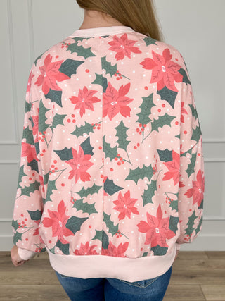 Pink knit long-sleeve top with poinsettia floral print, back view