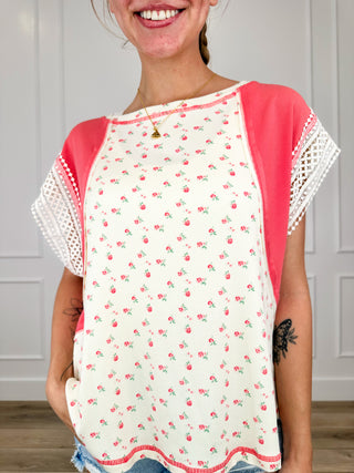 Cream rayon blend short sleeve top with red contrast raglan sleeves and floral print