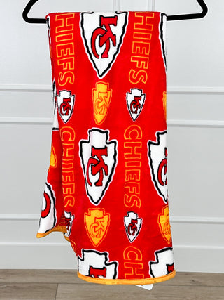 Red plush blanket with Kansas City Chiefs logos and CHIEFS text pattern