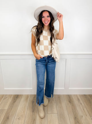 Outfit with beige plaid sleeveless top, light blue straight jeans, beige ankle boots, hat