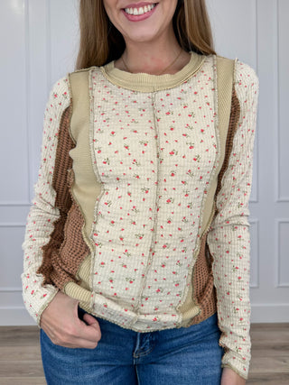 Long-sleeve cream top with red sprig print, tan yoke, round neck, button placket