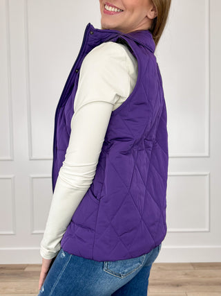 Purple sleeveless puffer vest with quilted design and angled side silhouette