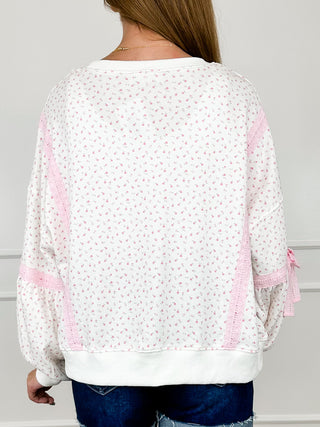 Cotton blend long sleeve top, white speckle print with pink ruffle cuffs; back view