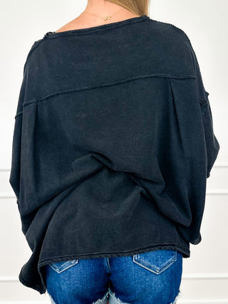 Cotton long-sleeve top, dark back view with knotted hem and relaxed drop-shoulder fit