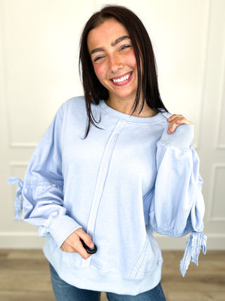 Light blue long sleeve cotton-blend top with drawstring hood and ruffled cuffs