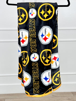 Black plush blanket with Pittsburgh Steelers logos and text pattern with circular emblems