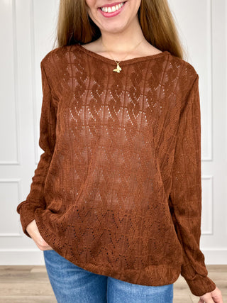 Rust brown knit long-sleeve top with textured pattern and round neckline