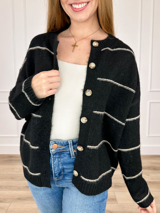 Black knit button-up cardigan with long sleeves, cream stripe trim, and front pockets