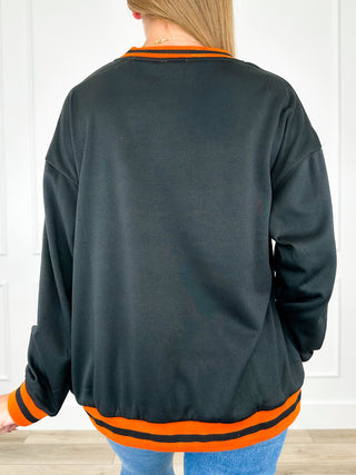 Dark crewneck sweatshirt with long sleeves and orange striped ribbed collar, cuffs, hem