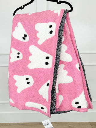 Pink fleece throw blanket with white animal faces and black trim