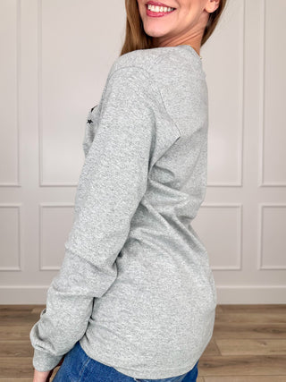 Grey long-sleeve graphic tee, side view; small star print near sleeve
