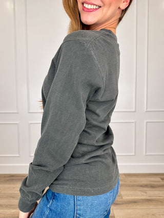Grey cotton long-sleeve crew tee, side view, solid fabric with no graphic visible