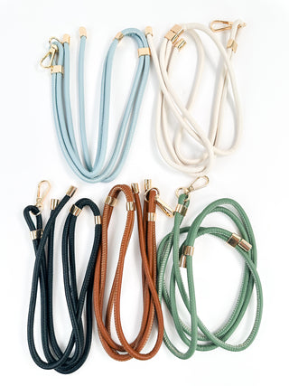 Assorted faux leather lanyards in black, light blue, bone, brown, and green