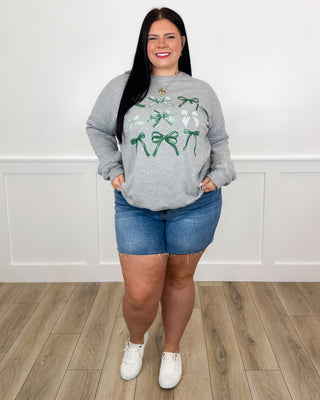 Gray sweatshirt with green bow graphic and blue denim shorts
