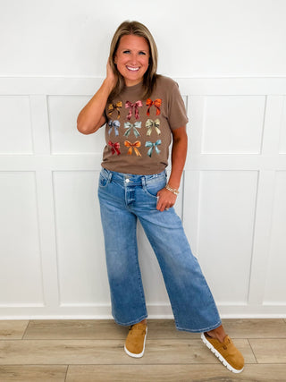 Casual outfit: brown graphic T-shirt with blue wide-leg jeans and tan sneakers