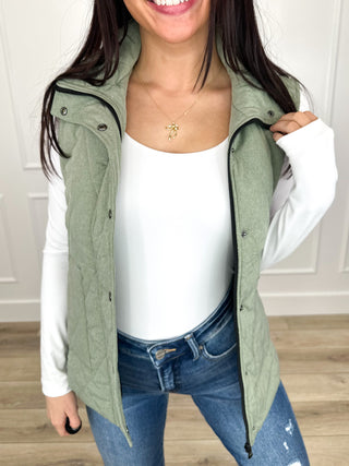 Sage green puffer vest with zip front and snap buttons, sleeveless