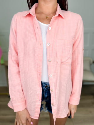Cotton long-sleeve button-up top in pink with button front and chest pocket.